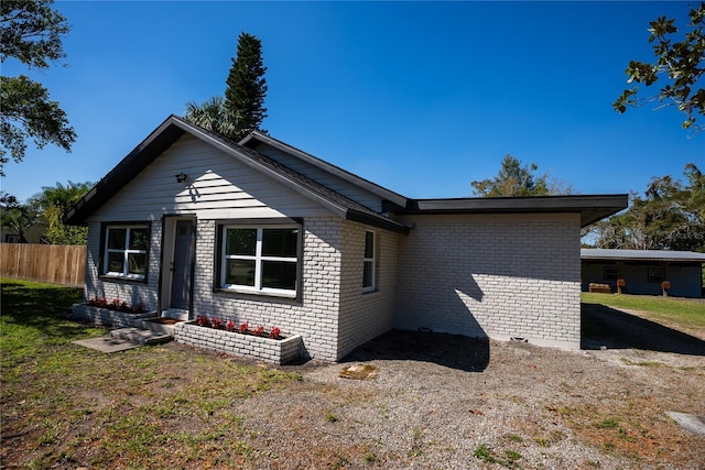 exterior space with brick siding and fence