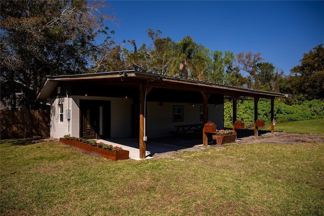 exterior space featuring a patio area, fence, concrete block siding, and a yard