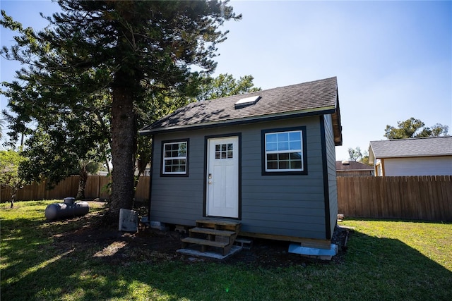 view of outbuilding with entry steps, fence private yard, and an outbuilding