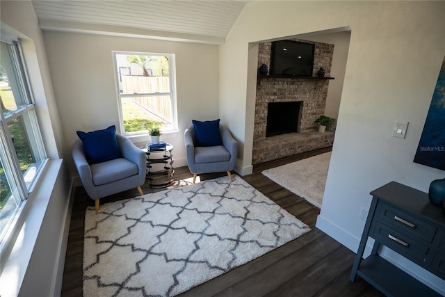 living room with vaulted ceiling, dark wood-style flooring, a fireplace, and baseboards