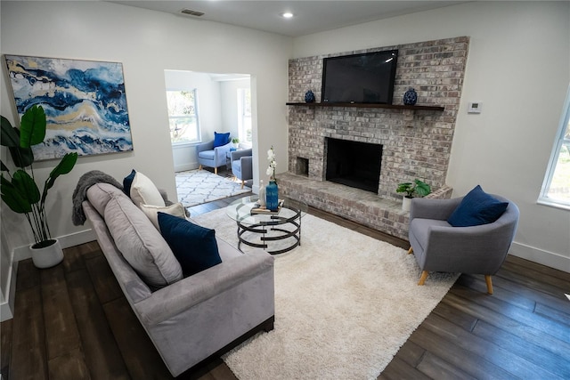 living area with baseboards, visible vents, wood finished floors, a fireplace, and recessed lighting