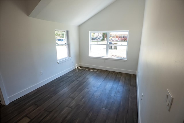 unfurnished room with lofted ceiling, dark wood-type flooring, and baseboards