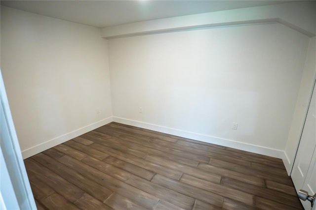 unfurnished room with dark wood-type flooring and baseboards