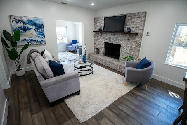 living room featuring a fireplace, baseboards, wood finished floors, and recessed lighting