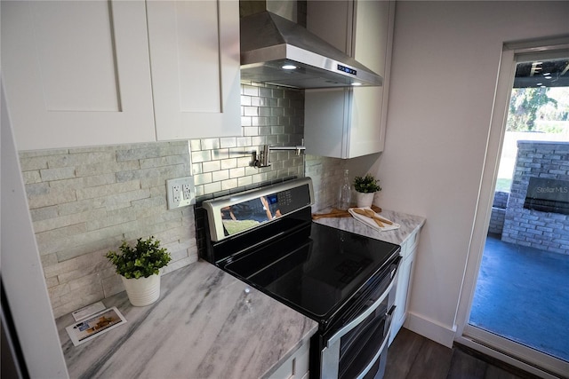 kitchen with white cabinets, extractor fan, decorative backsplash, and stainless steel range with electric cooktop