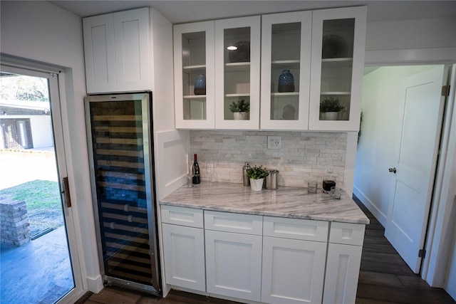 bar with baseboards, wine cooler, dark wood-type flooring, and tasteful backsplash