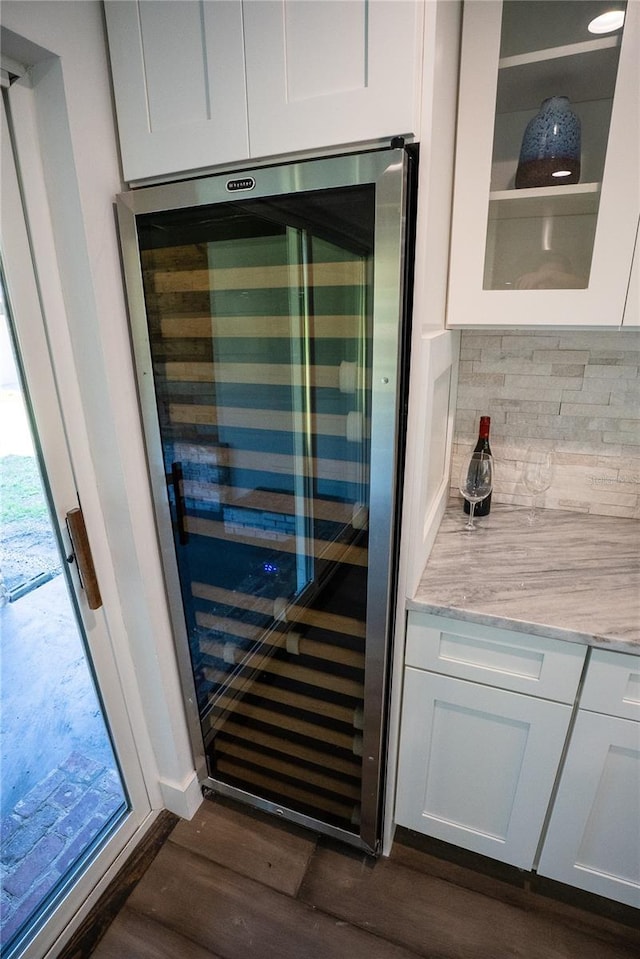 details featuring beverage cooler, white cabinets, light stone countertops, dark wood-style floors, and tasteful backsplash