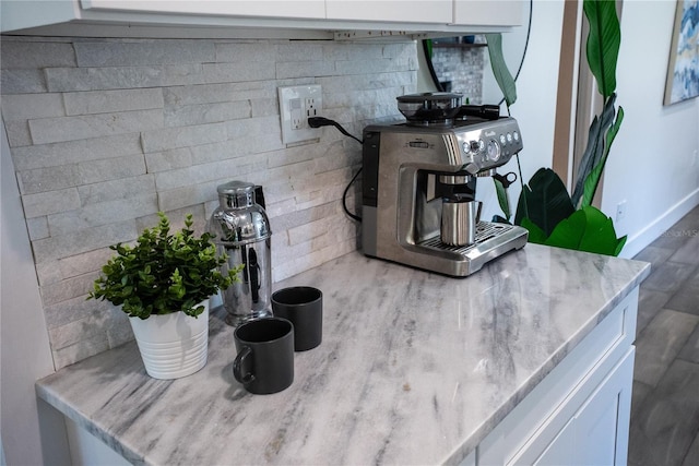 interior details with white cabinetry and light stone countertops