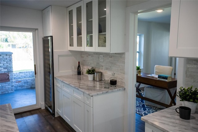 bar featuring dark wood-style flooring and backsplash