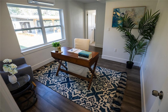 office space featuring a wall unit AC, baseboards, and wood finished floors