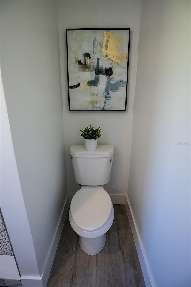 bathroom featuring wood finished floors, toilet, and baseboards