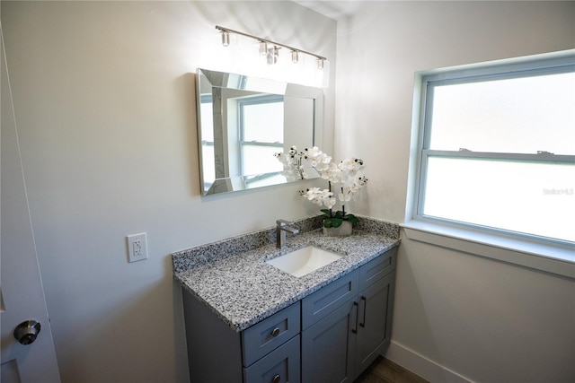 bathroom with vanity, a wealth of natural light, and baseboards