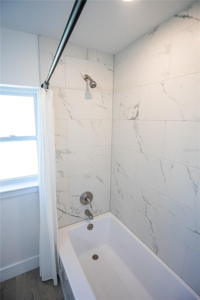 bathroom with shower / bath combination with curtain and baseboards