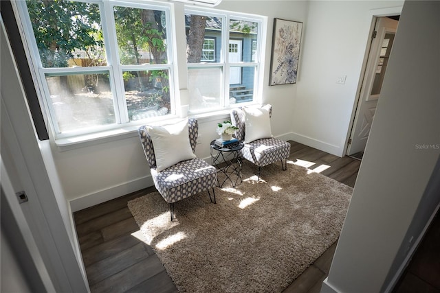 living area with baseboards and wood finished floors