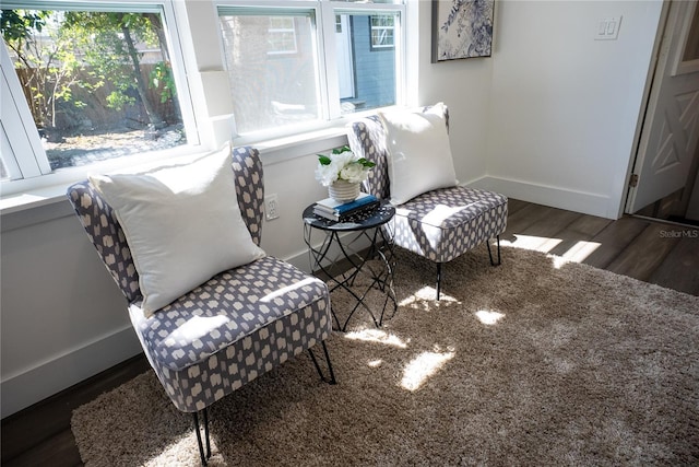 living area with baseboards and wood finished floors