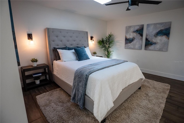 bedroom with ceiling fan, wood finished floors, and baseboards