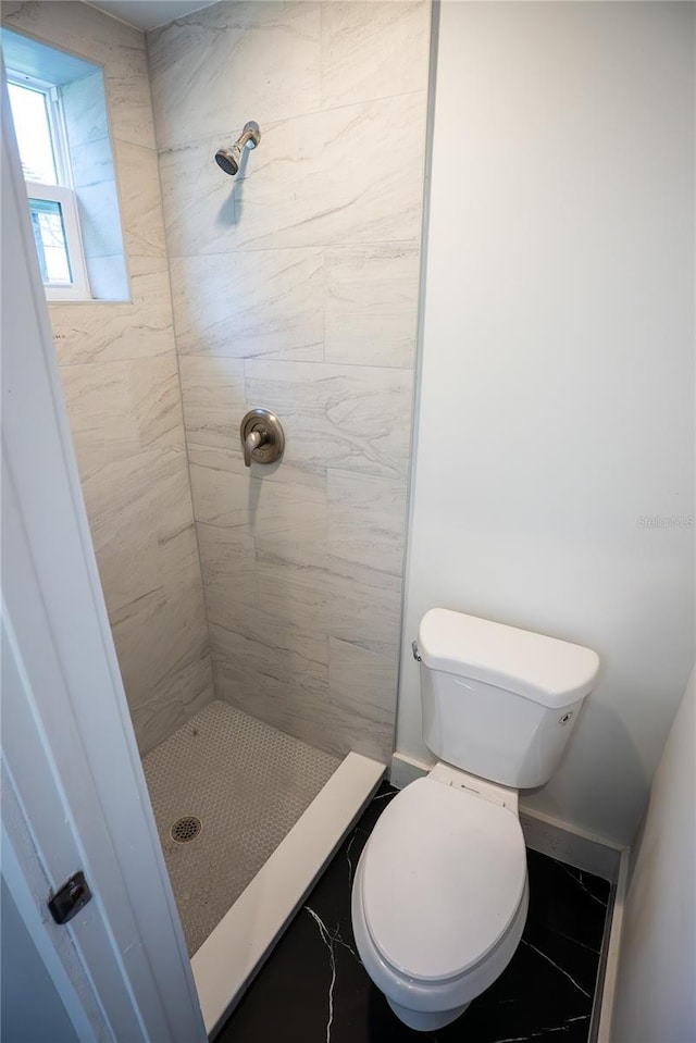 full bath featuring a stall shower, baseboards, and toilet