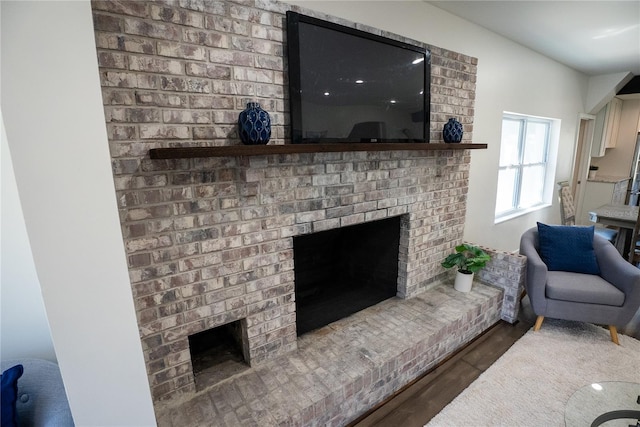 living room with a fireplace and wood finished floors