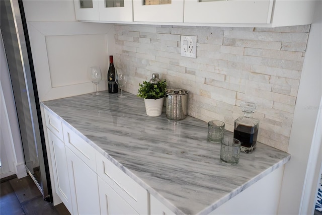 interior space with light stone counters and white cabinetry