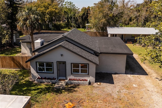 ranch-style house featuring brick siding, a front lawn, and fence