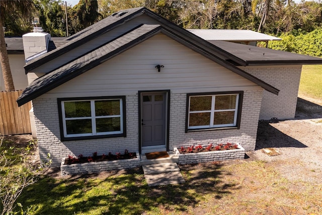 bungalow-style house featuring fence and a front lawn