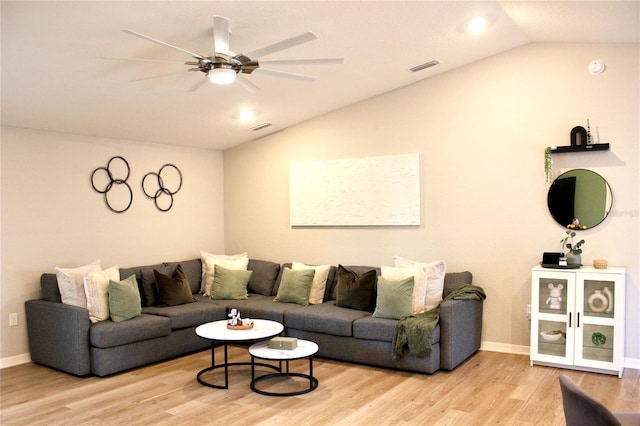 living area with light wood-type flooring, visible vents, and vaulted ceiling