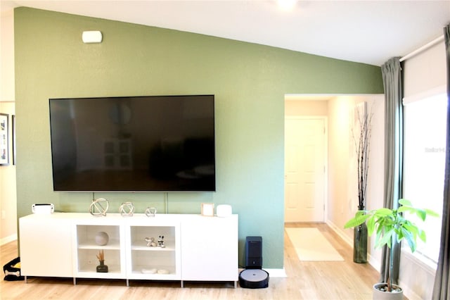 living room with lofted ceiling, baseboards, and wood finished floors