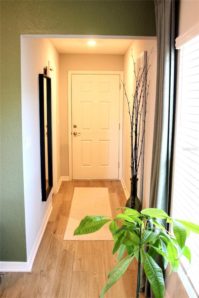 entryway with light wood-style flooring and baseboards