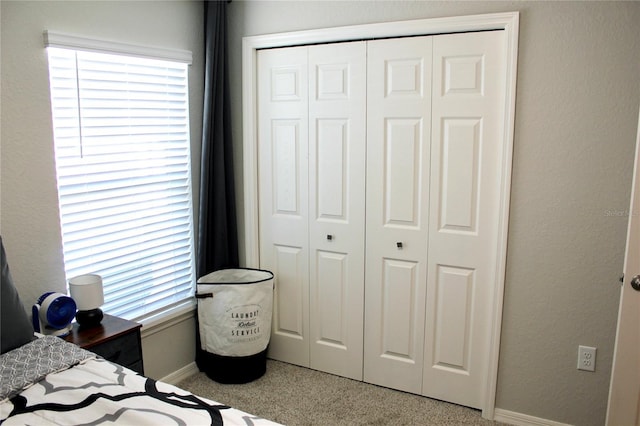 bedroom with carpet flooring, a closet, multiple windows, and baseboards