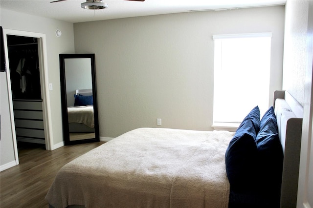 bedroom with wood finished floors, a ceiling fan, and baseboards