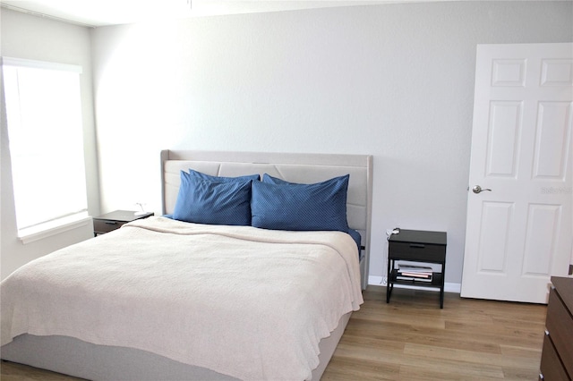 bedroom with wood finished floors and baseboards