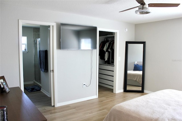 bedroom featuring light wood-style floors, baseboards, a textured ceiling, and ensuite bathroom