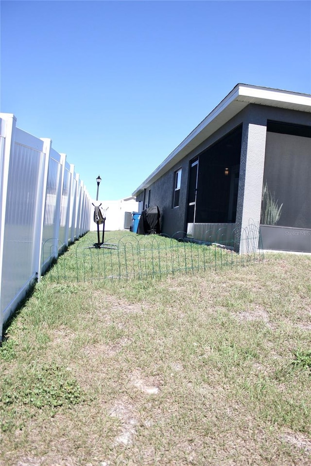 view of yard with fence and a sunroom