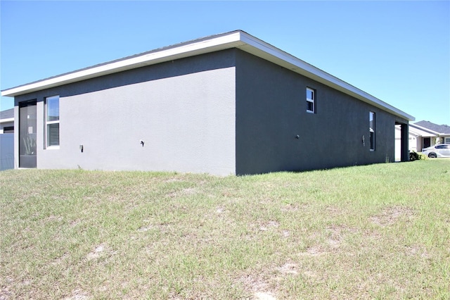 view of home's exterior with a yard and stucco siding