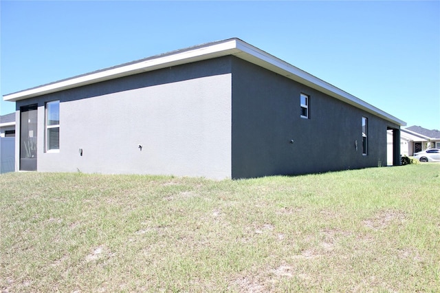 view of property exterior with a yard and stucco siding