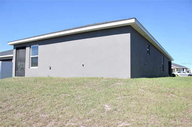 view of property exterior with a lawn and stucco siding