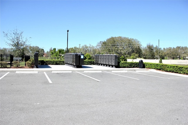 uncovered parking lot with fence and mail area