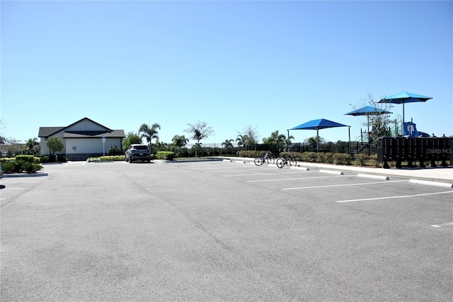 uncovered parking lot featuring mail area and fence