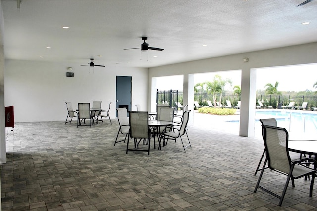 view of patio featuring outdoor dining space, fence, a ceiling fan, and a fenced in pool