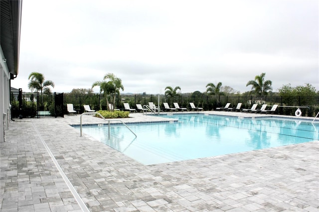 pool with fence and a patio