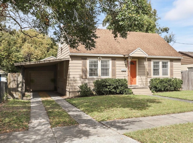 view of front facade with driveway, a shingled roof, an attached garage, fence, and a front yard