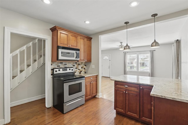 kitchen with recessed lighting, wood finished floors, decorative backsplash, and stainless steel electric stove