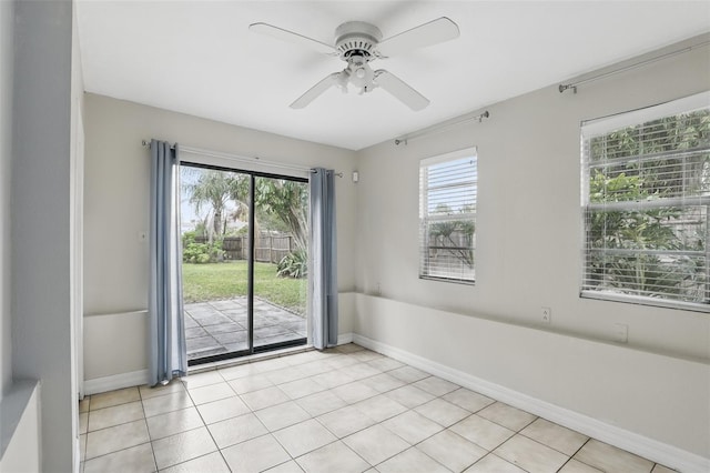 unfurnished room with ceiling fan, light tile patterned floors, and baseboards