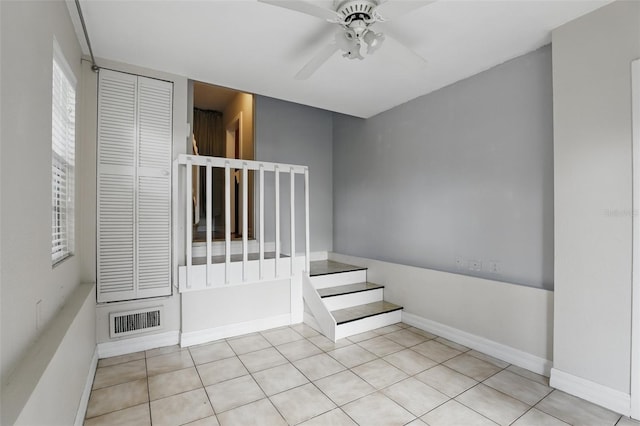 staircase with a ceiling fan, tile patterned flooring, visible vents, and baseboards