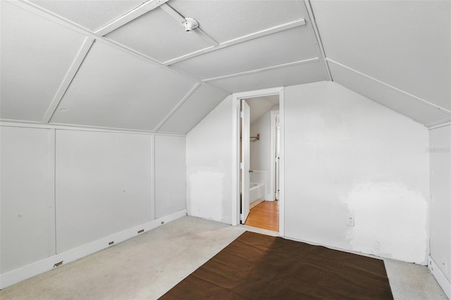 additional living space with vaulted ceiling and carpet