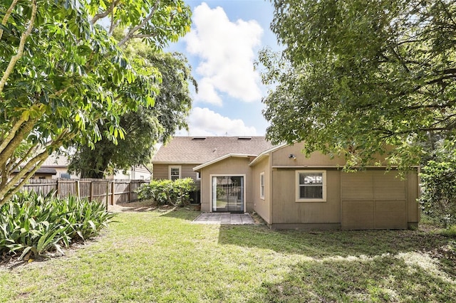 rear view of house featuring fence private yard and a yard