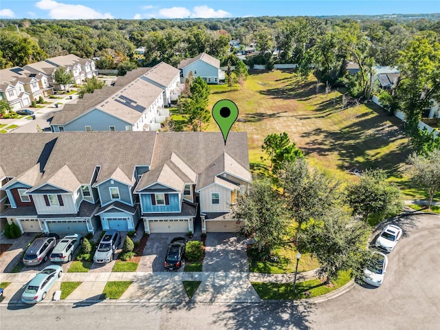 drone / aerial view featuring a residential view and a view of trees