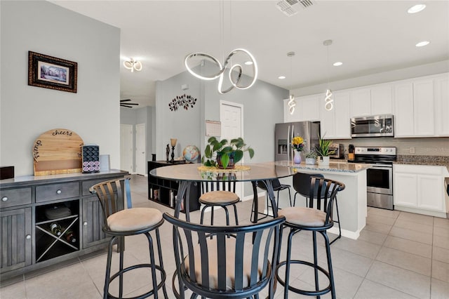 kitchen with visible vents, backsplash, appliances with stainless steel finishes, light tile patterned flooring, and white cabinetry