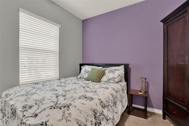 bedroom featuring baseboards and light colored carpet