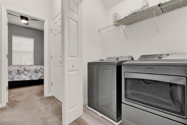 laundry room featuring light carpet, laundry area, washing machine and clothes dryer, and baseboards